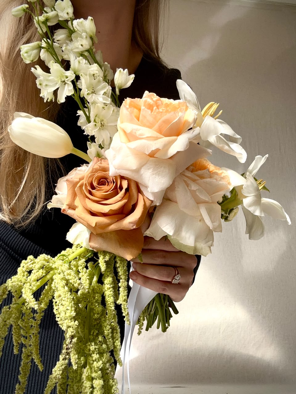 Copper-toned roses gathered with white cymbidium orchid and chamomile
