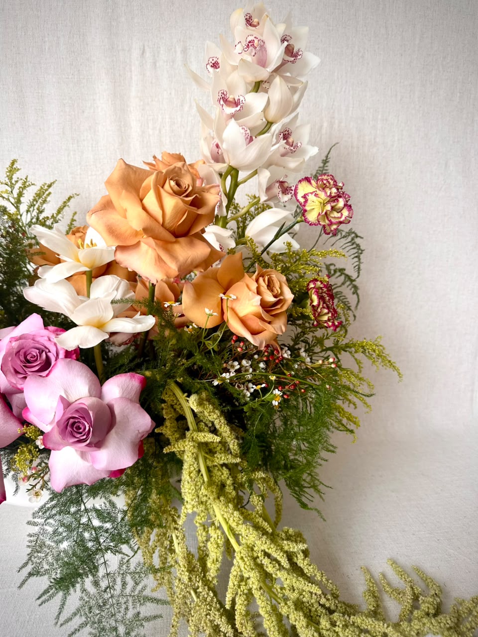 Pink parrot tulips and an open white tulip rising from a clear vase